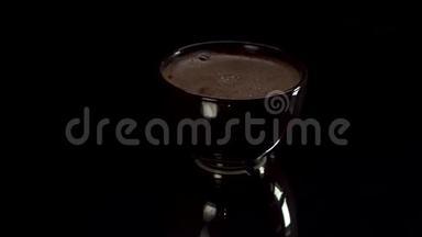 咖啡杯在黑桌上旋转。